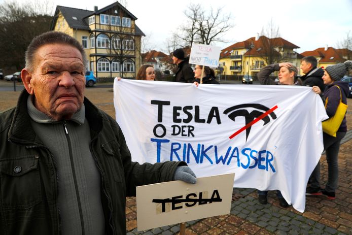 Demonstranten houden anti-Teslabordjes en -spandoeken vast. 'Tesla of drinkwater' staat er op het spandoek.