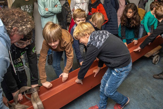 Leerlingen van De Springplank helpen een handje mee om het staal voor de verbouwing van de bovenverdieping in het gebouw aan de Groenstraat op de juiste plek te krijgen.