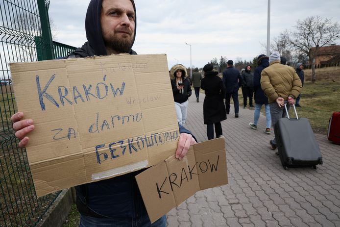 Deze man uit de Poolse stad Krakau staat bij een Poolse grensovergang en biedt vluchtelingen uit Oekraïne transport aan richting Krakau.