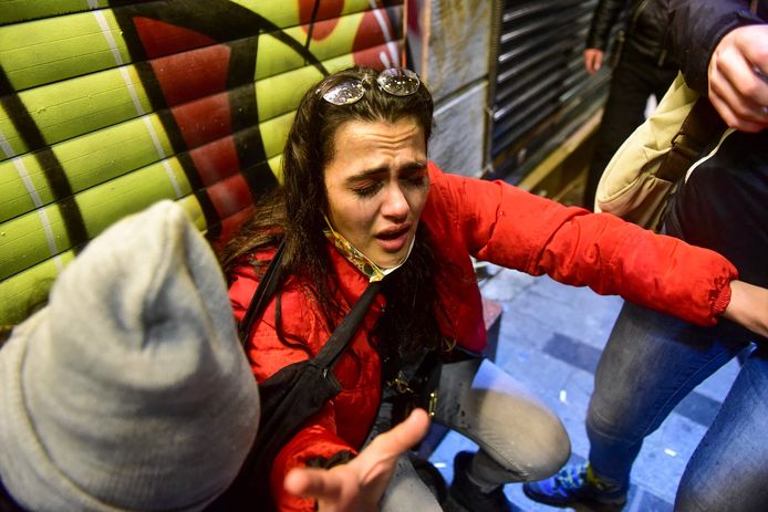Een van de demonstranten die werd getroffen door een wolk pepperspray, wordt bijgestaan door omstanders.