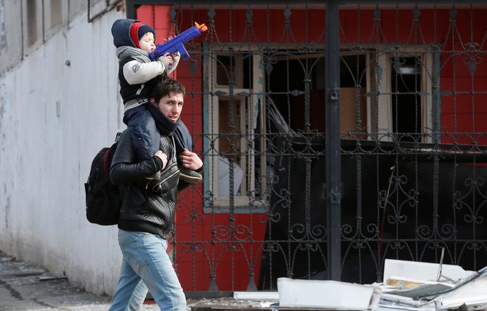 Inwoners lopen door de zwaarbeschadigde stad Marioepol.