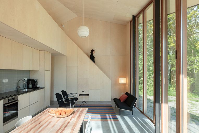 Overdag is het huis een vloeiende open ruimte, met doorzicht naar buiten. ‘s Avonds worden de bedden,
die verstopt zitten in het centrale meubel, uitgeklapt.  Beeld Sebastian van Damme