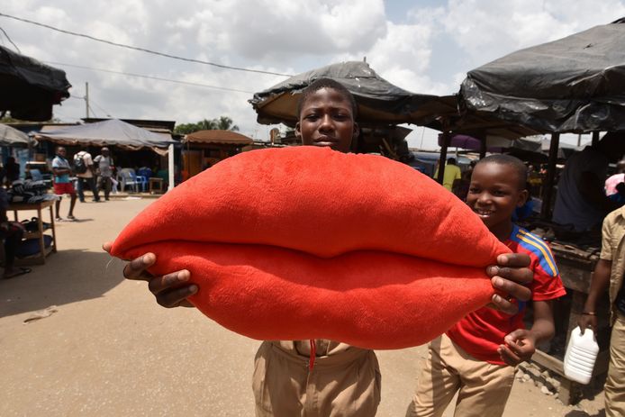 Een jongen probeert speciaal voor valentijnsdag een kussen op de markt te verkopen in Abidjan op de Ivoorkust. Foto Sia Kambou