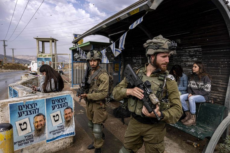 Israëlische soldaten op wacht bij een busstation, vlak bij de Joodse nederzetting Kfar Tapuach ten zuiden van Nabloes, op de Westelijke Jordaanoever.
 Beeld AFP