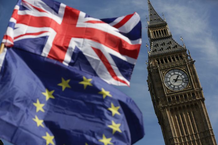 De Big Ben in Londen, met op de voorgrond de Britse en Europese vlaggen.