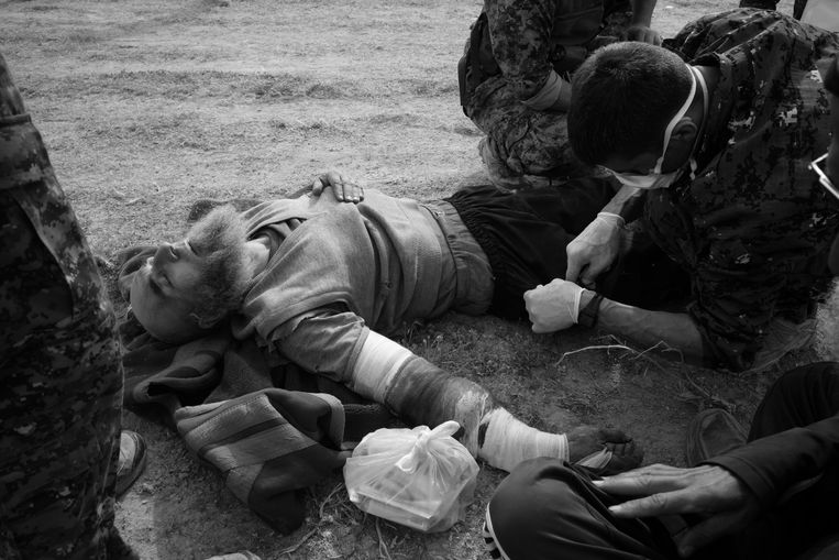 Een zwaar gewonde IS strijder wordt ter plaatse behandeld, zijn overlevingskans is vrij klein, het transport naar de gevangenis kan vele uren tot een dag duren. Beeld Eddy van Wessel