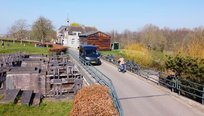 Een automobilist en een fietsster passeren elkaar ter hoogte van de Dalemsluis bij Gorinchem. Op de vernieuwde dijk blijven auto's welkom.