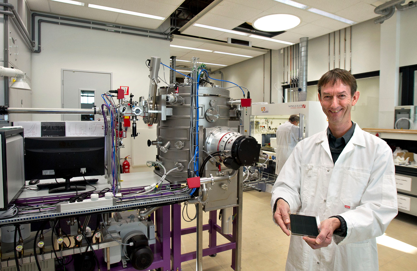 Ando Kuypers bij een onderdeel van de machinelijn voor zonnecellen bij Solliance. Archieffoto.