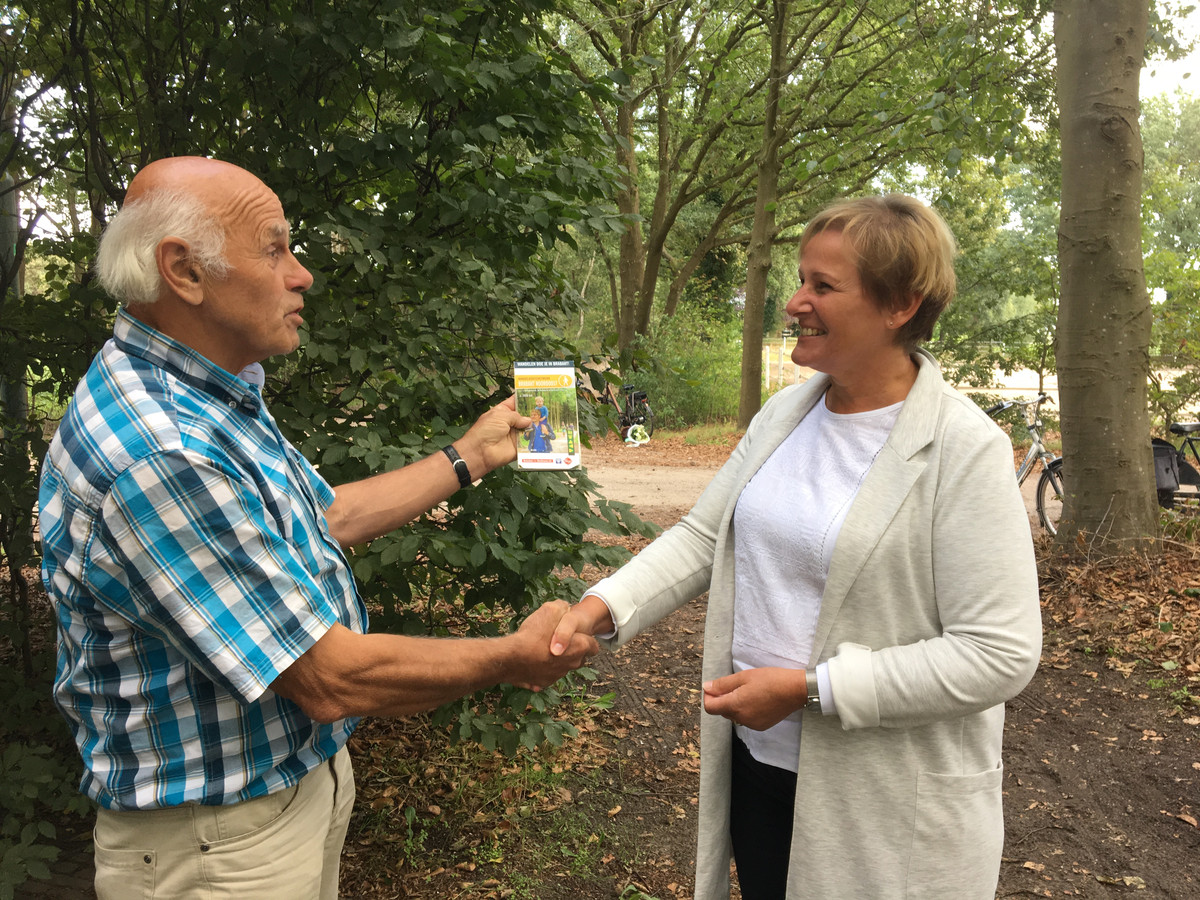 Wethouder Coby van der Pas ontvangt de nieuwe wandelroutekaart van Meierijstad uit handen van vrijwilliger Martien Verbakel.
