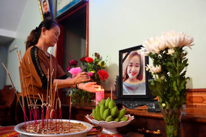 De mama van Anna Bui Thi Nung (19) steekt een kaars aan bij een foto van haar vermiste dochter.