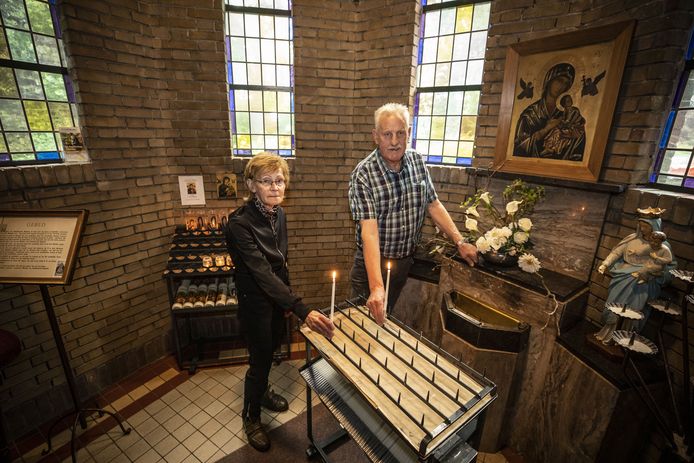 Hoofdkoster Herman Groote Punt en hulpkoster Ans Brummelhuis steken een kaarsje aan in de kapel.