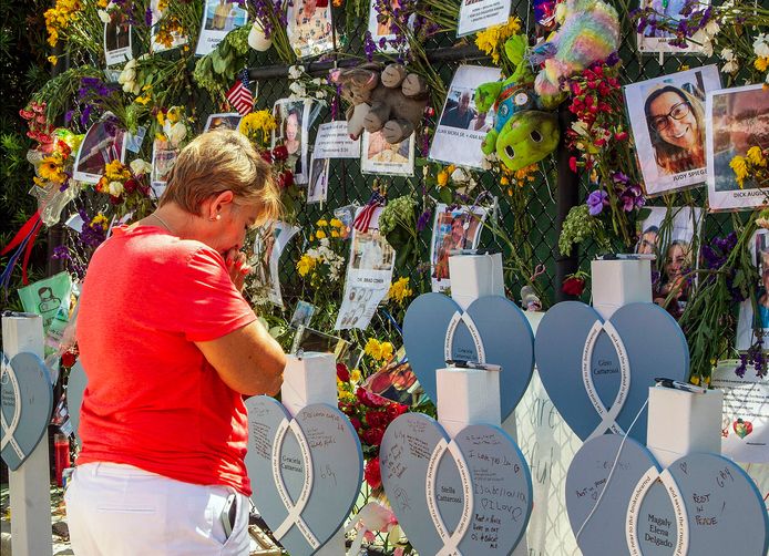 Een vrouw is geëmotioneerd bij de herdenkingsplaats van de 86 mensen die omkwamen bij de instorting van het appartementsgebouw in Miami.
