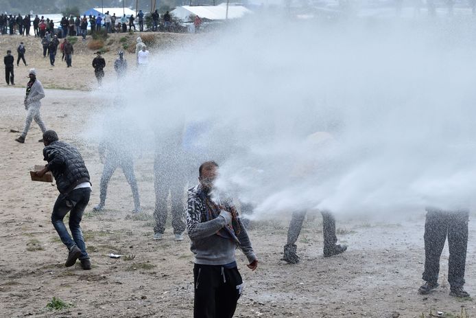 Franse politieagenten zetten traangas en waterkanonnen in om de vluchtelingen weg te jagen.