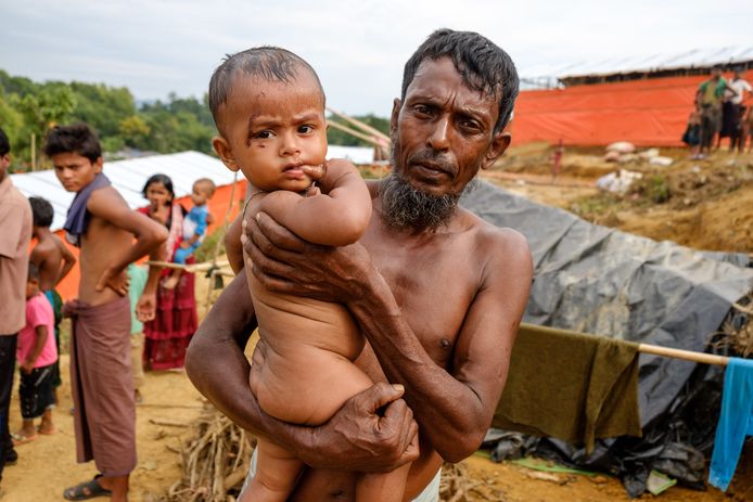 Een man houdt zijn kind vast in het Kutupalong vluchtelingenkamp voor Rohingya in Bangladesh.
