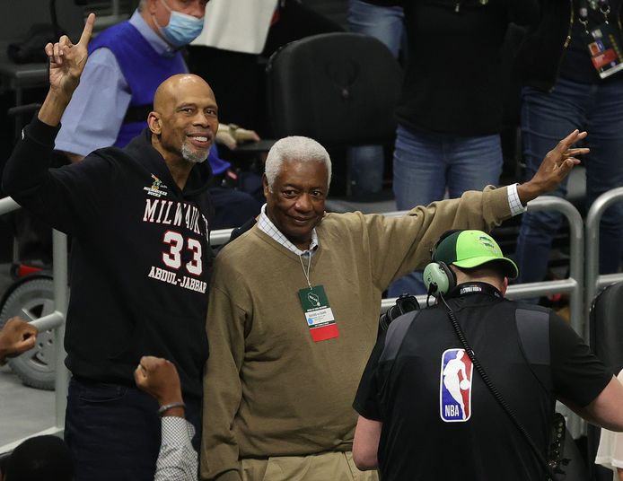 Kareem Abdul-Jabbar (l) en Oscar Robertson, twee spelers uit de kampioensploeg van 1971, moedigen hun oude club aan.