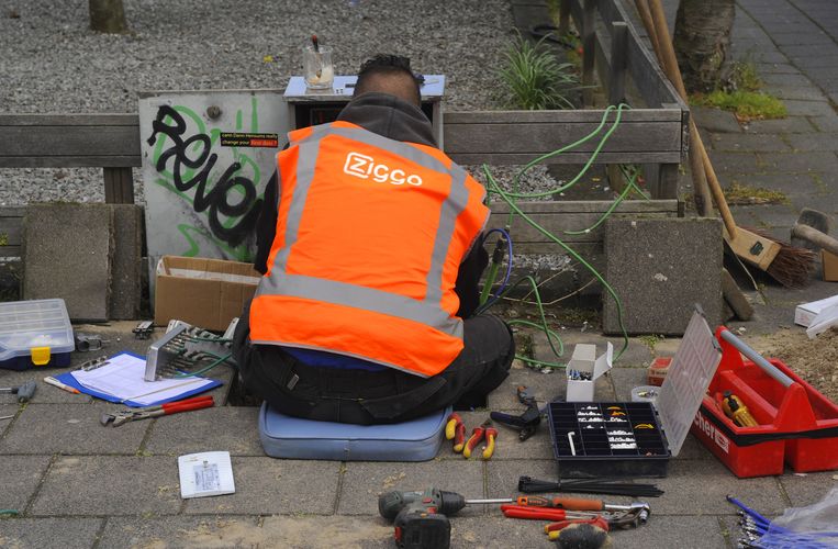 Een technicus van Ziggo, leverancier van (digitale) tv en radio, internet en telefonie via de kabel, werkt op straat aan een verdeelkast. Beeld  Paul van Riel / Hollandse Hoogte
