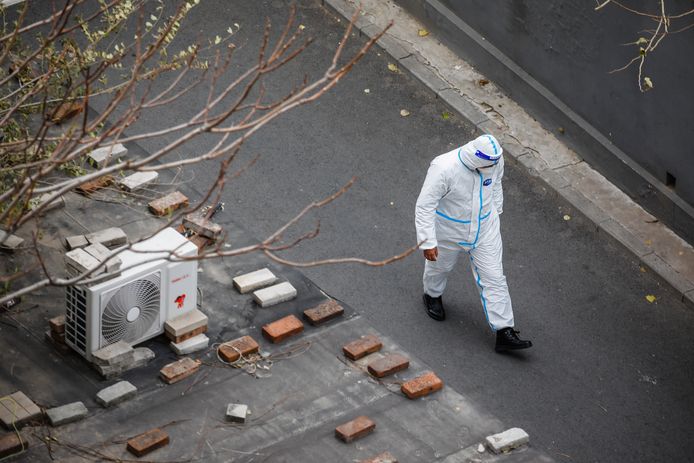 Un agent sanitaire travaillant près d'un immeuble avec des cas de Covid confirmés.