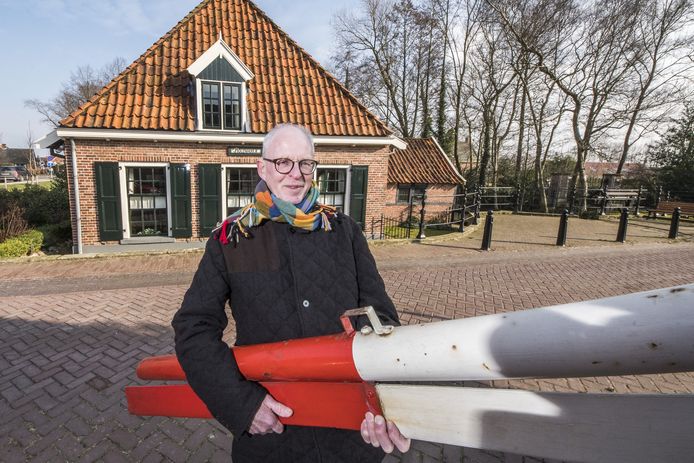 Gerard Hassink met slagboom van de grensovergang die wordt geschonken aan Heemkunde Ootmarsum