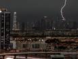 Pikdonkere wolken en een bliksemschicht tijdens hevige regenval dinsdag in Dubai.