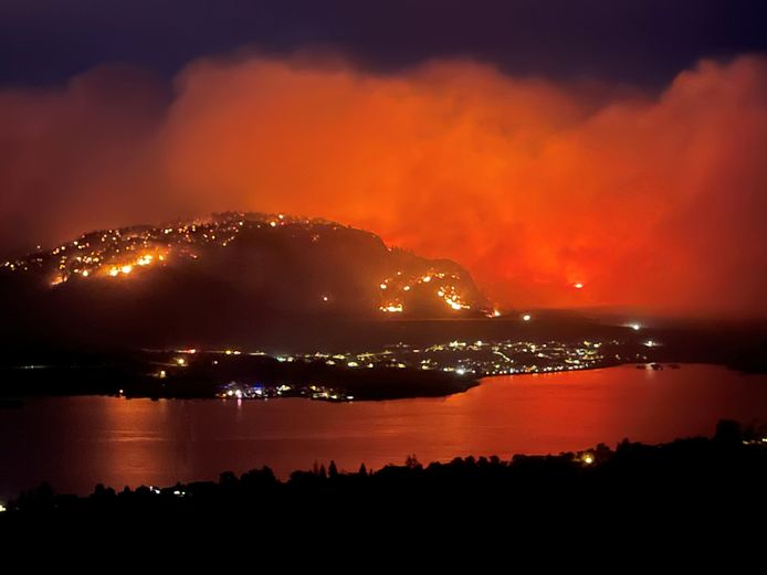Oranjegekleurde rookwolke stijgen op vanaf een bosbrand bij de stad Osoyoos in de Canadese provincie British Columbia.