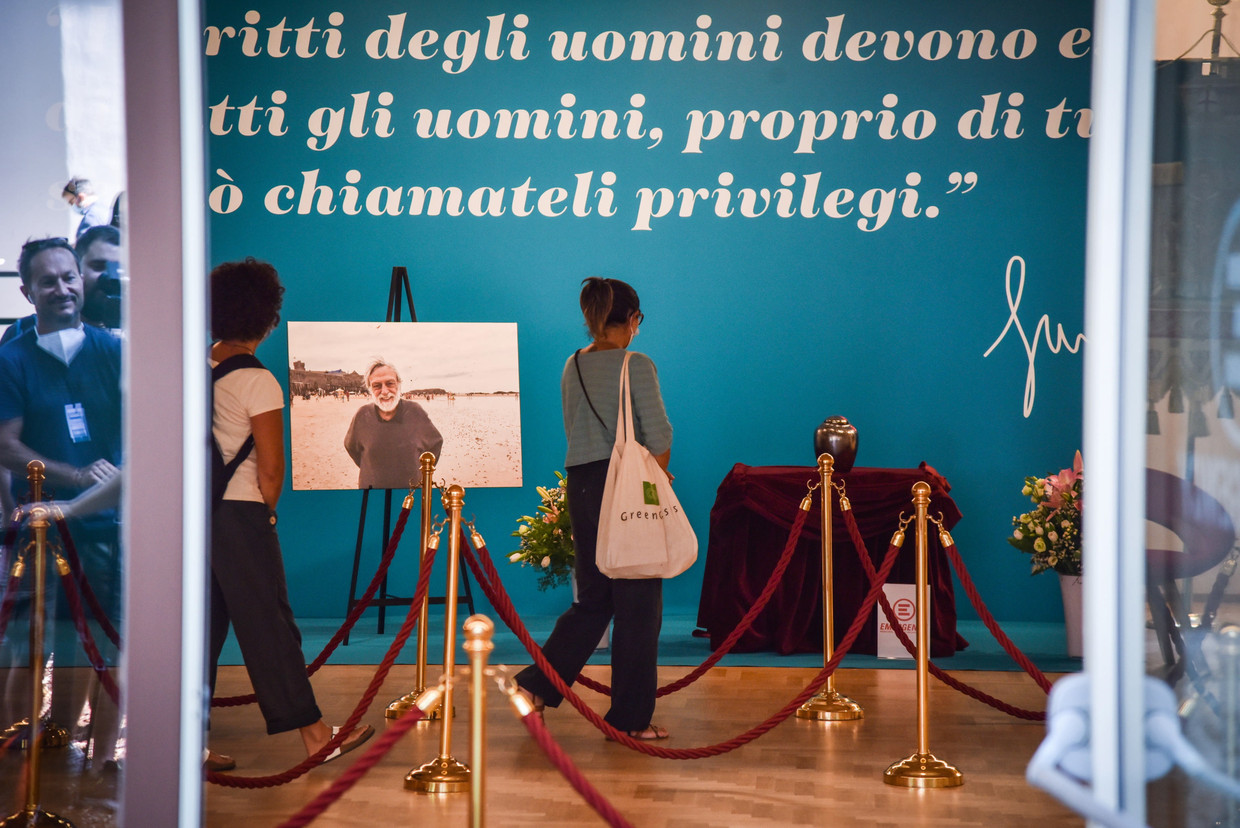 'Mensenrechten moeten de rechten van iedereen zijn, echt van iedereen, anders moet je ze privileges noemen', staat op de wand bij de condoleance voor Gino Strada in Milaan. Beeld EPA