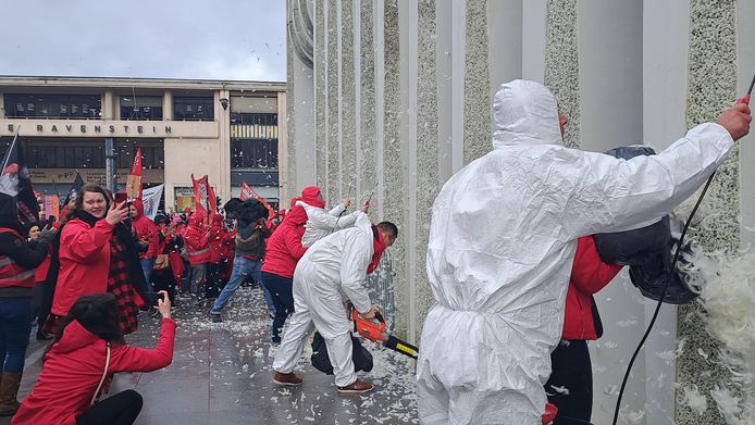 Protesteerders besmeuren het hoofdgebouw van BNP Paribas Fortis met 'pek en veren'.