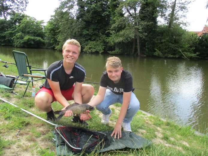 Tom Hendriksen (links) en Jari Elzinga: deze karper valt een beetje tegen. De twee Hengeloërs vissen in de vijver in het Laurapark in hun woonplaats.