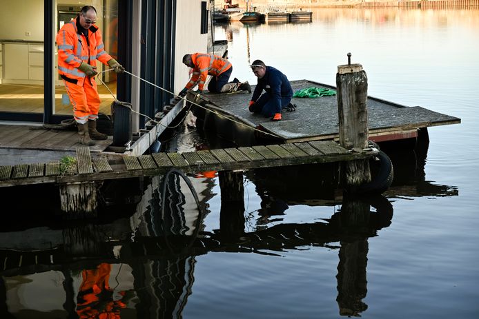Medewerkers van kraanbedrijf Maathuis bekijken de situatie vanaf een ponton.