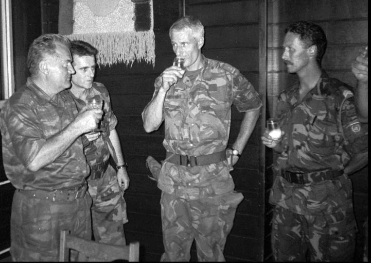 11 juli 1995. De Nederlandse commendant Thom Karremans (tweede van links) heft het glas met Ratko Mladic. Dezelfde dag nog valt Srebrenica en beginnen de moordpartijen. Beeld © ap