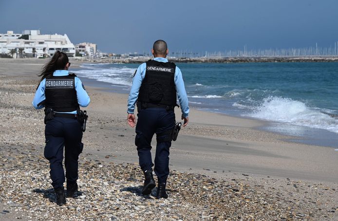 Franse agenten op het verlaten strand van het Zuid-Franse Palavas les Flots, nabij Montpellier. Vanwege het coronavirus blijven veel Franse stranden mogelijk nog lang verboden gebied voor buitenlandse toeristen.