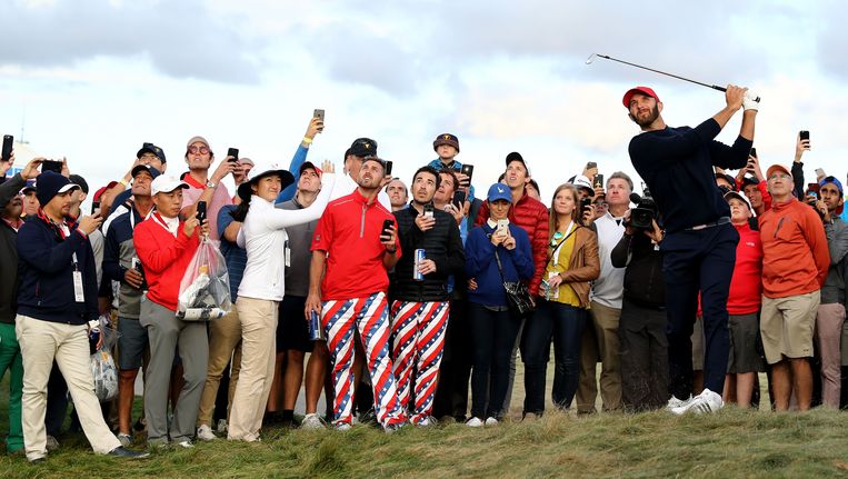 Dustin Johnson van team USA met een horde fans achter zich. Beeld afp