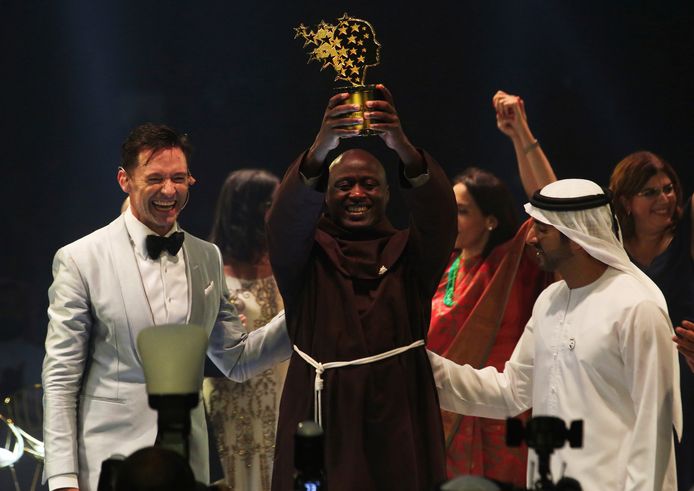 Peter Tabichi houdt zijn trofee omhoog. Rechts van hem staat sheikh Hamdan bin Mohammed Al Maktoum, kroonprins van Dubai.