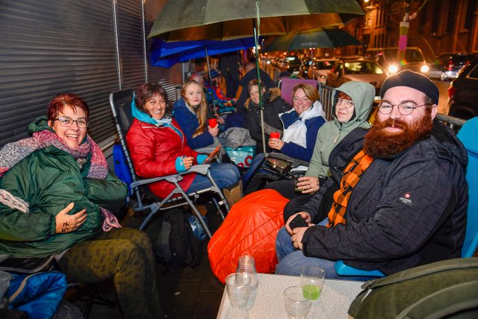 Ondertussen loopt de rij tot in de Kerkstraat. Iedereen probeert het zich zo comfortabel mogelijk te maken.