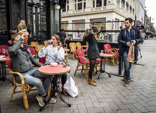 Terrasgangers drinken hun laatste drankje op het Leidseplein in Amsterdam.