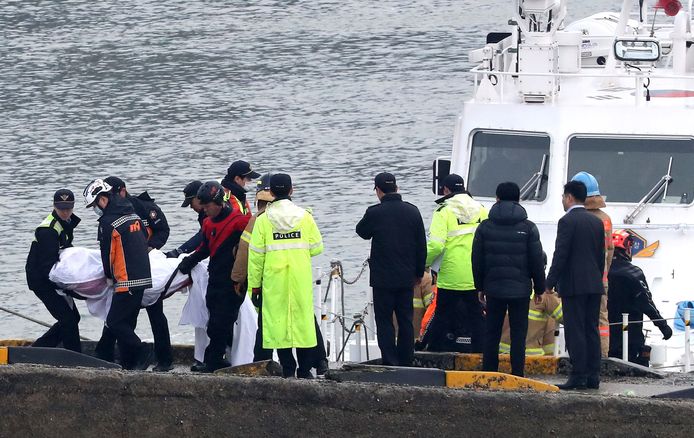Reddingswerkers bergen de lichamen van de opvarenden van de Zuid-Koreaanse vissersboot.