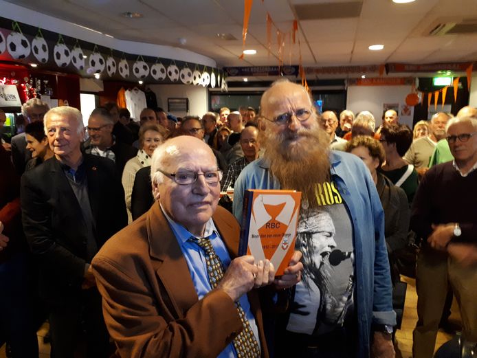 Clubicoon Kees Vermunt (l.) krijgt uit handen van schrijver Eddy Janssen het eerste exemplaar van het jubileumboek voor 105 jaar RBC 'Meer dan een eeuw oranje' uitgereikt.