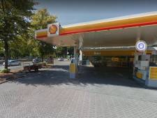Verwarde man pakt slang Shellstation en houdt vlam bij benzineplas