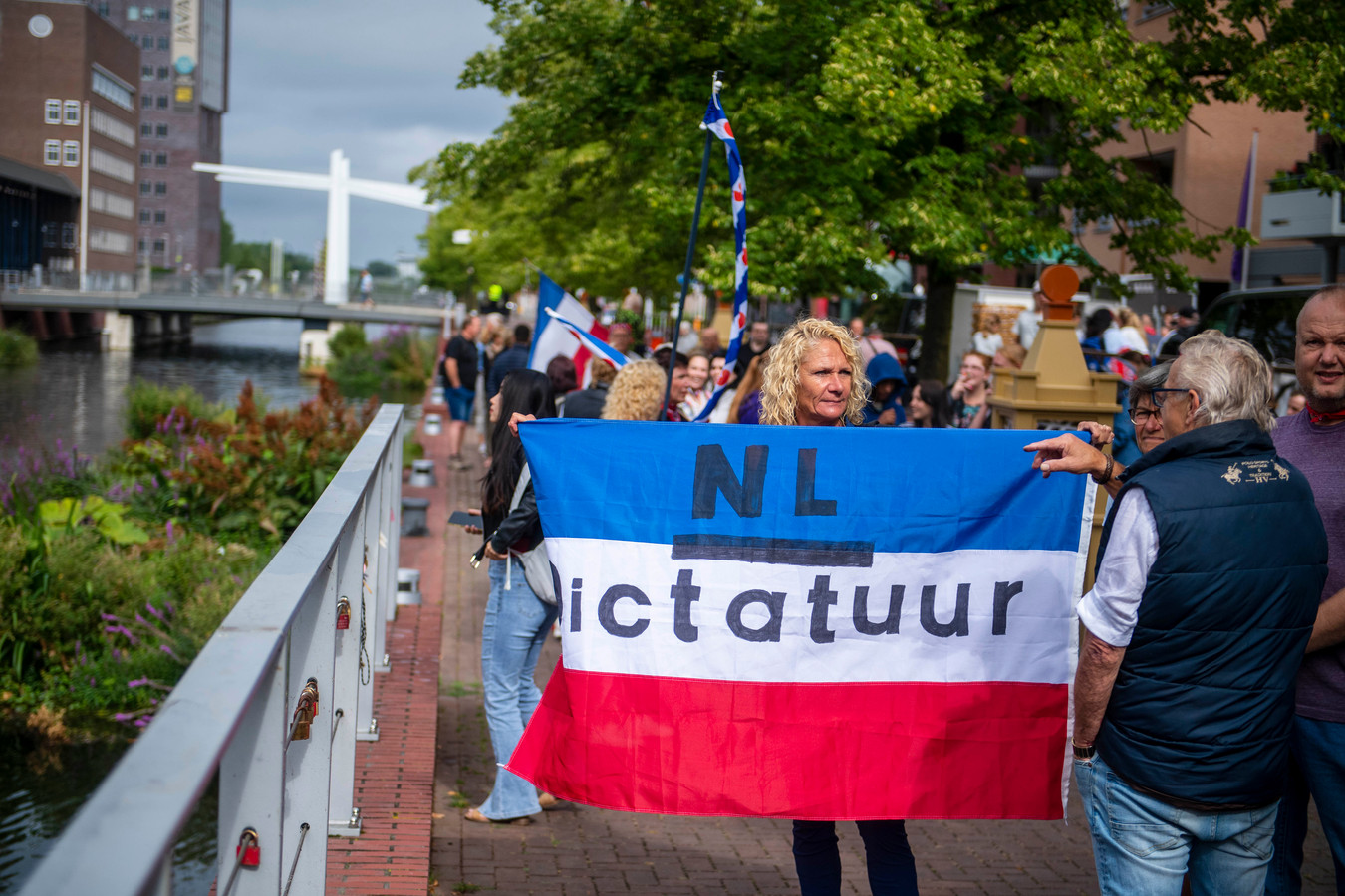 Een vrouw, geen boerin, toont een omgekeerde Nederlandse vlag tijdens het protest in Almelo. Na de middag liep het uit de hand. Een groot deel van de boeren was toen al weg.