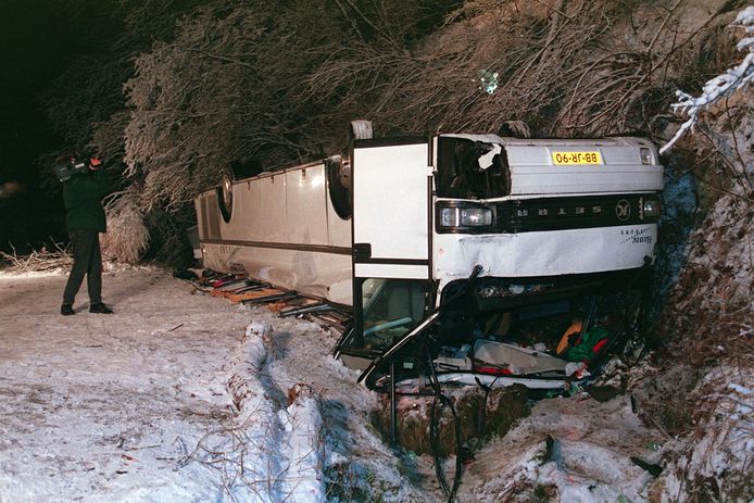 De bus van Hanzetours ligt op de kop in het dal.