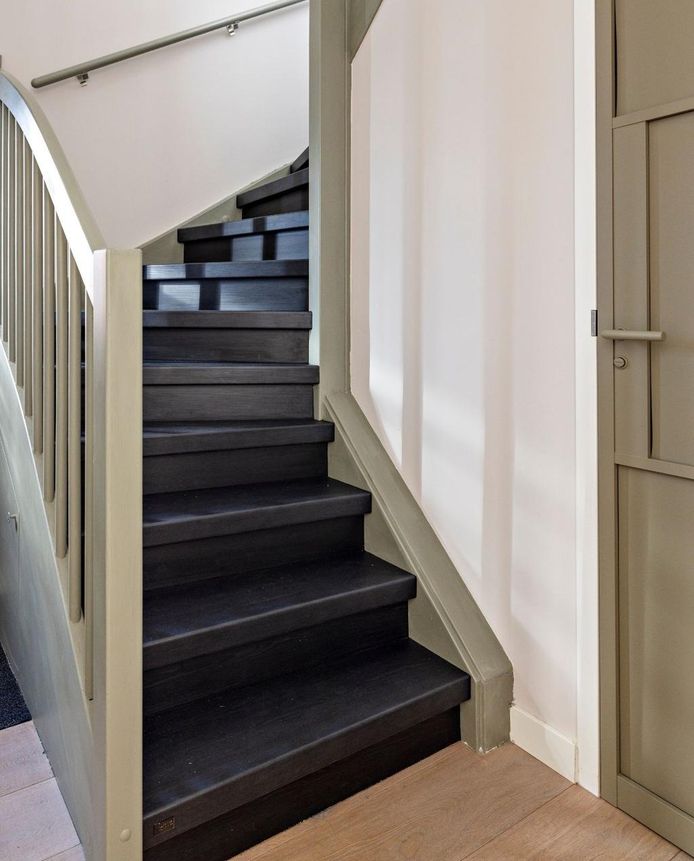 De trapleuningen en trapomlijsting zijn in dezelfde kleur geschilderd als de wc-deur.
