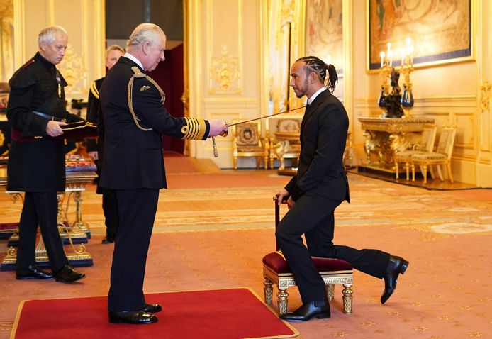 Lewis Hamilton wordt tot ridder geslagen door prins Charles.