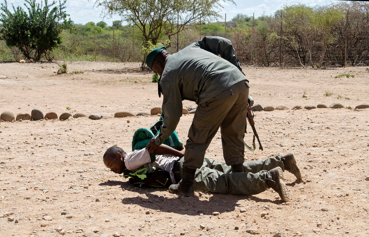 Rangers in Mozambique rekenen een 'stroper' in tijdens een oefening eerder dit jaar. De autoriteiten wilden journalisten graag demonstreren dat het hen ernst is met de aanpak van stroperij. Zij werken daarbij samen met Zuid-Afrika. Beeld EPA