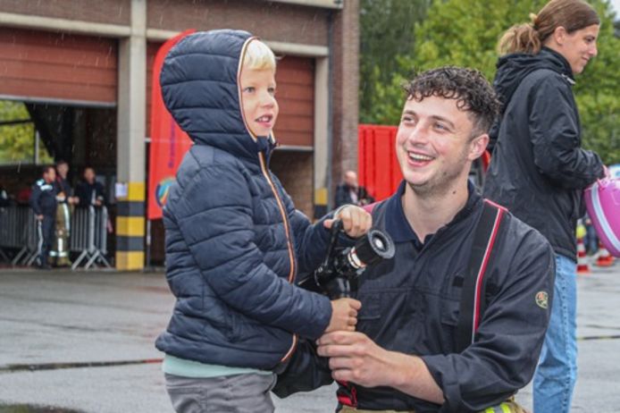 Een kind samen met een brandweerman tijdens de jaarlijke opendeurdag in Herentals