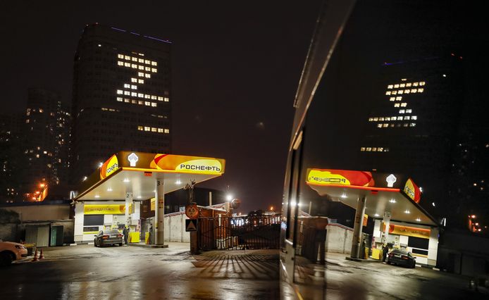 Een tankstation van het Russische olieconcern Rosneft in Moskou, voor een gebouw van het Russische gasconcern Gazprom waarop de letter 'Z' met lichten te zien is. Beeld van exact een jaar geleden.