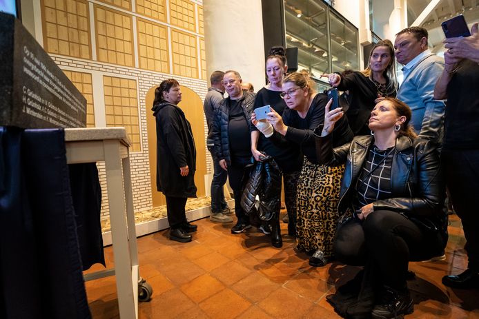 Familieleden maken foto's en bekijken de Plaquette met daarop de namen van de 13 Bossche Roma en Sinti die vermoord zijn in concentratiekampen.