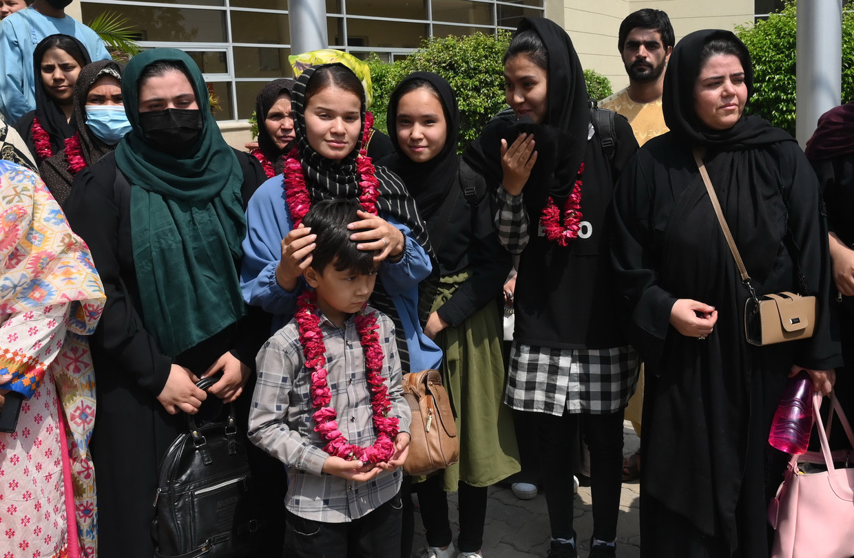 Afghaanse voetbalsters en familie na het passeren van de grens met Pakistan. Beeld EPA