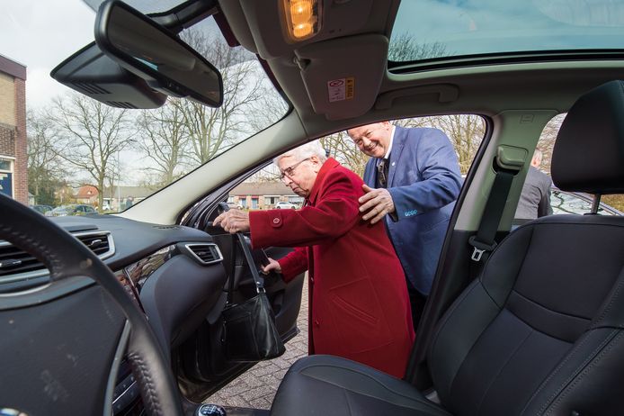 Wethouder van Oosterhout helpt de 90-jarige mevrouw de Rooijen - Polak in de auto. Foto René Schotanus/Pix4Profs