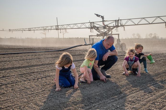 Uienteler Bert de Bruijckere met zijn twee dochters, een neefje en een nichtje op een uienperceel dat hij noodgedwongen moet beregenen.