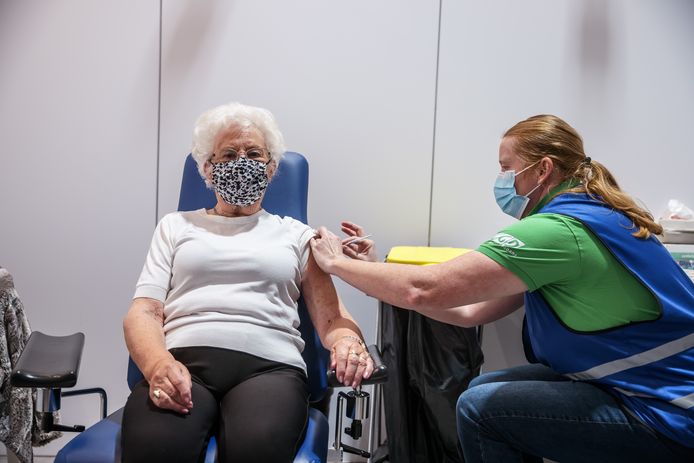 Een oudere dame ontvangt de booster op Breda International Airport.