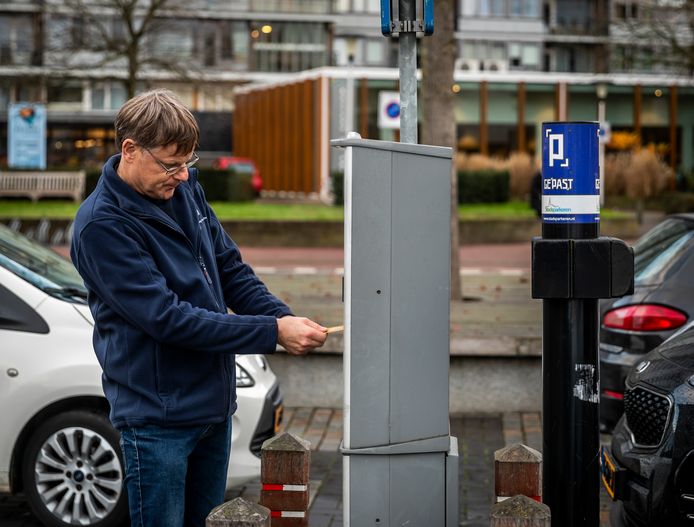 Een man betaalt om te parkeren bij een automaat in Helmond.
